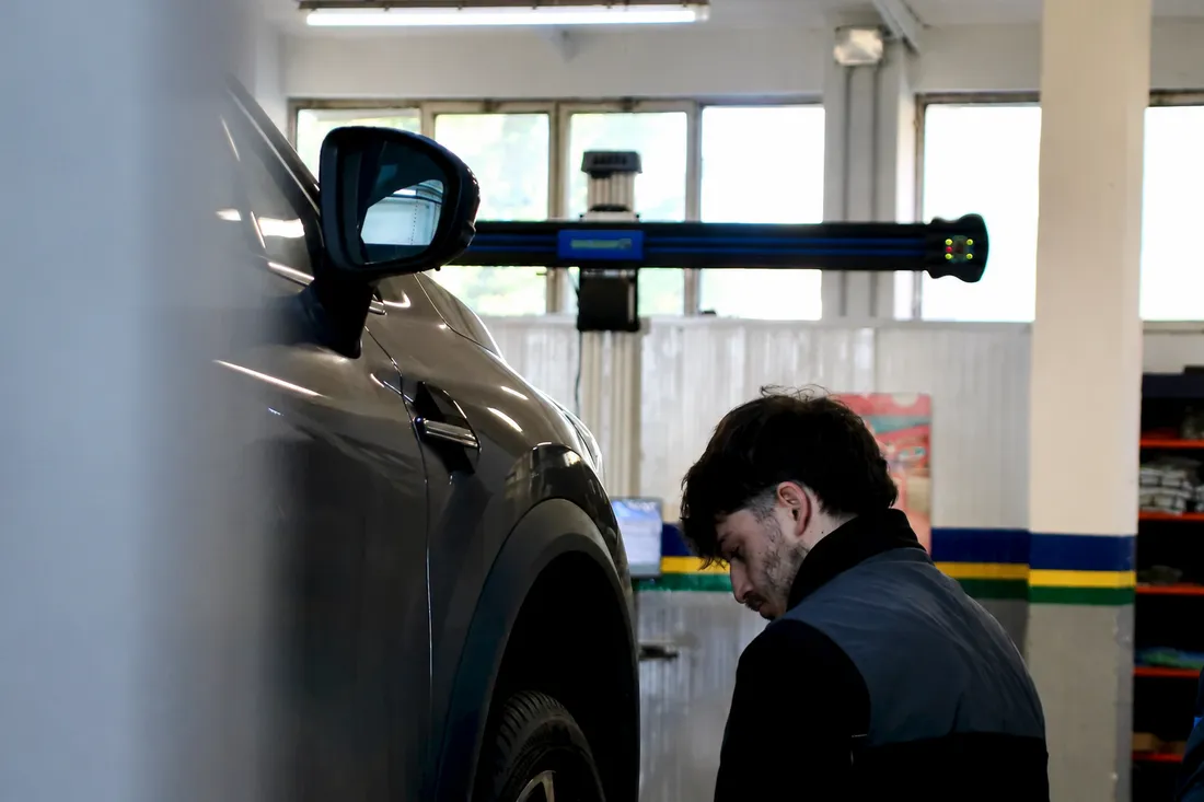 A mechanic checking a car wheel in a workshop