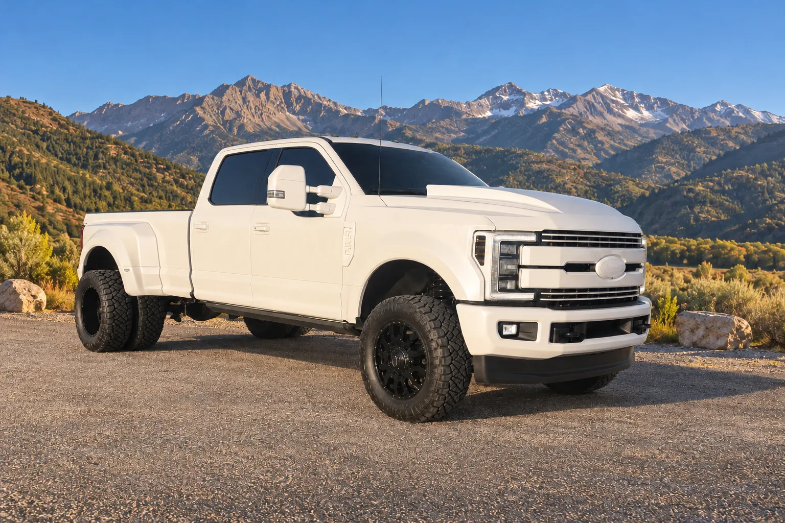 A white Ford dually with a digitally created Utah mountain background